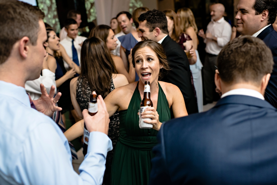 A bridesmaid sings into her beer on the dance floor during the reception at Vie.